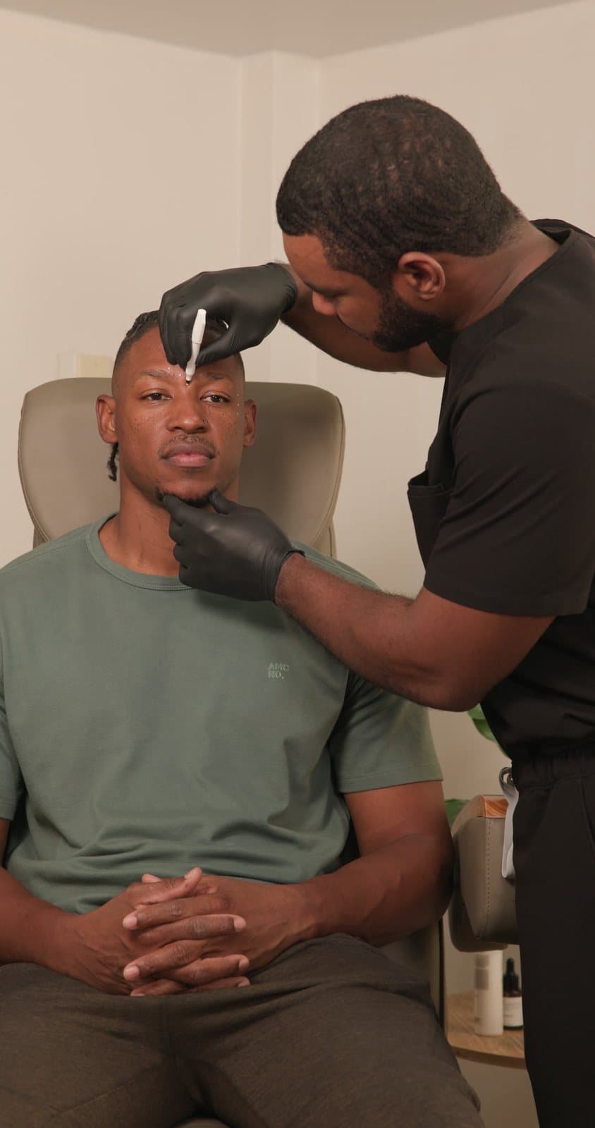 Dr. Breedy assessing a client's face before treatment