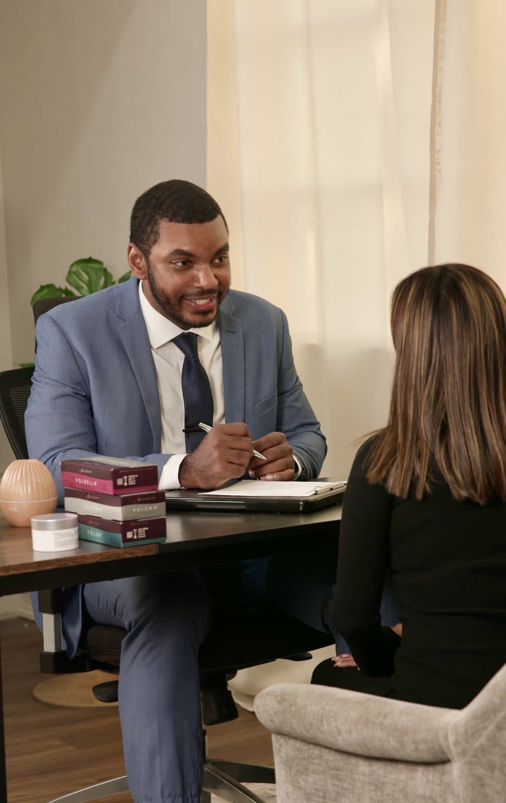 Dr. Breedy in conversation across a desk during a consultation